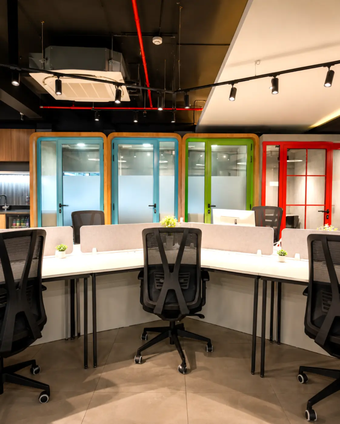 Open coworking desks and private phone booths at a Spunic workspace