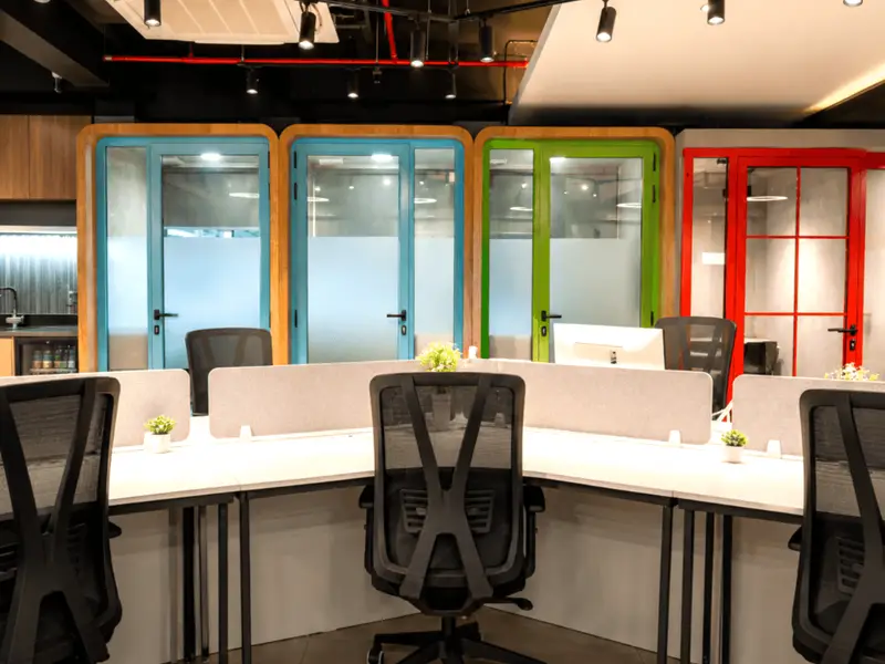 Open coworking floor at Spunic, with desks and private phone booths.