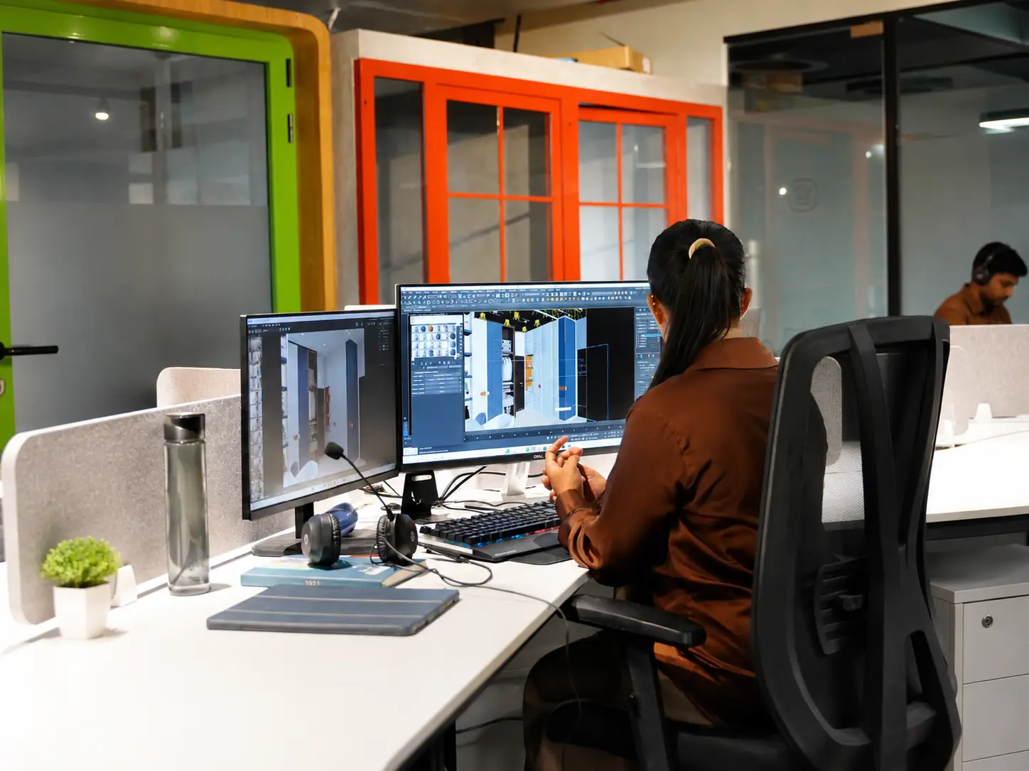 Person working at a dual-monitor coworking desk at Spunic Kondotty