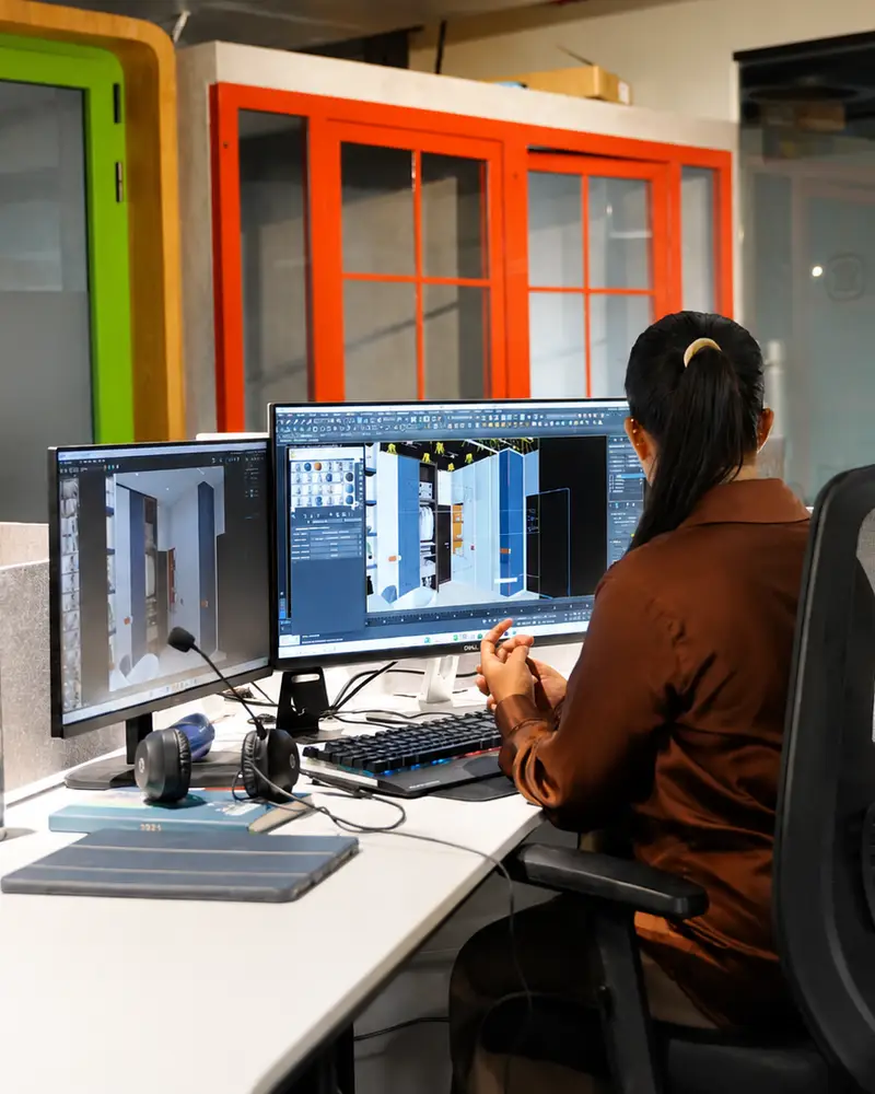 Person working at a dual-monitor coworking desk at Spunic Kondotty