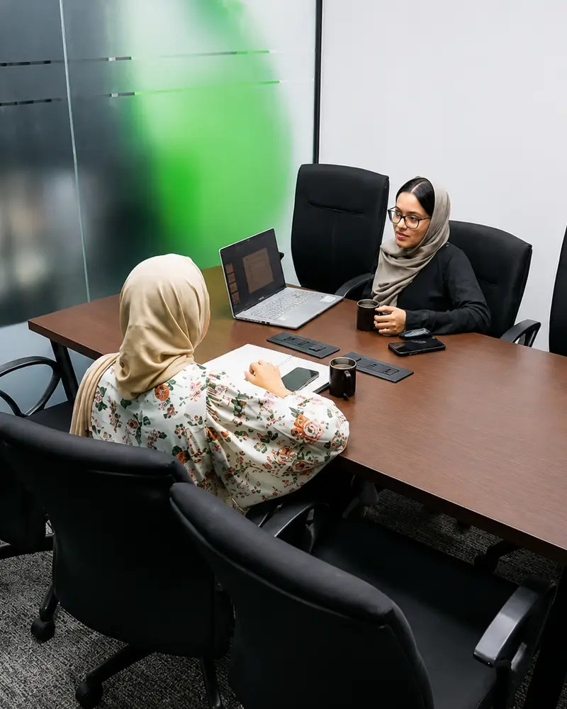 Two professionals in a consultation meeting at a conference table